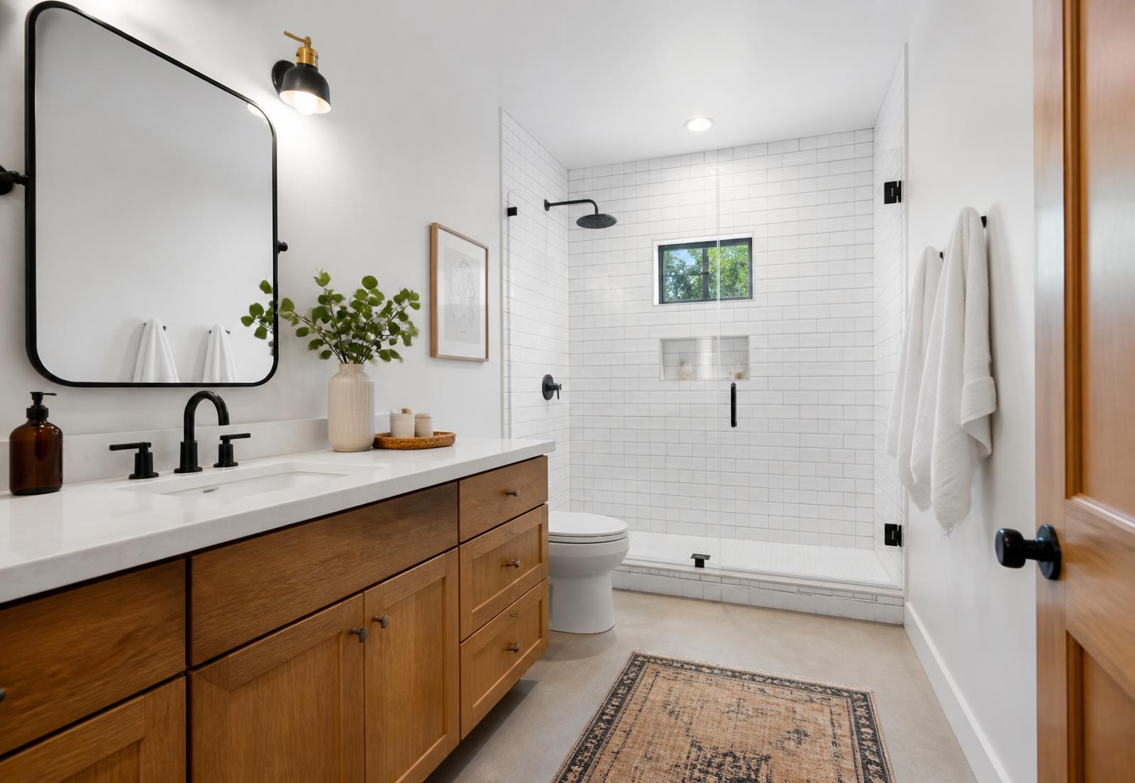 Renovated bathroom with a tiled walk-in shower and modern wood vanity